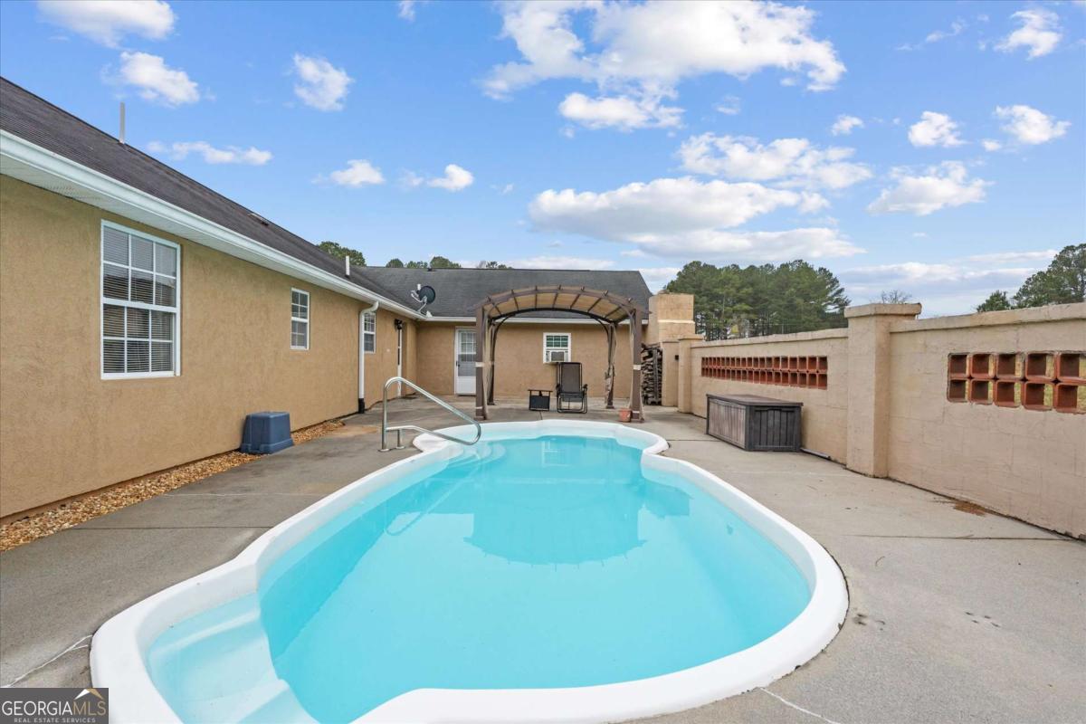 40-l Z L Z Jackson Road Bowdon, GA 30108 - Photo 26 of 32 a view of a house with swimming pool and sitting area