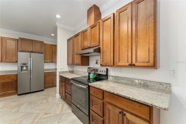 a kitchen with granite countertop a sink stainless steel appliances and cabinets