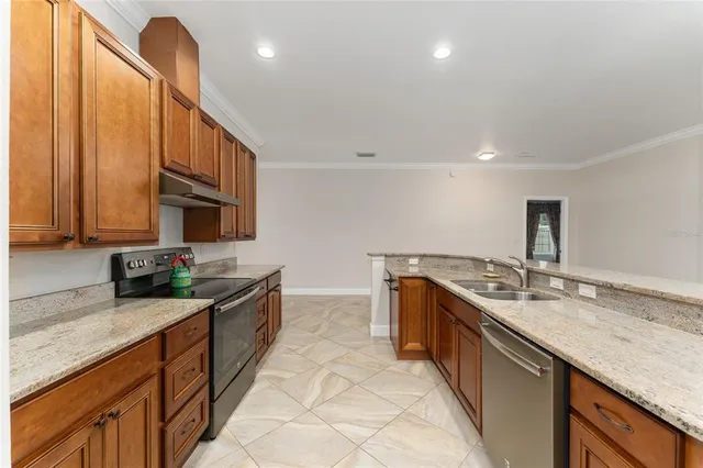 a kitchen with stainless steel appliances granite countertop sink stove and cabinets