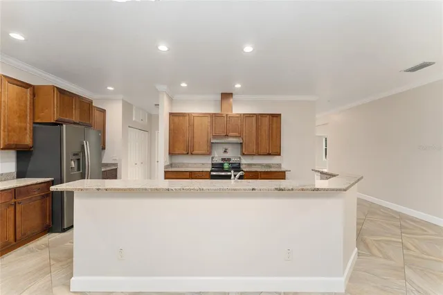a view of a kitchen with kitchen island a sink stainless steel appliances and cabinets