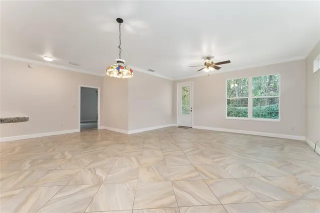 a view of a room with windows and ceiling fan