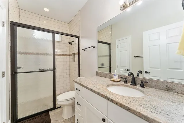 a bathroom with a granite countertop sink toilet and shower