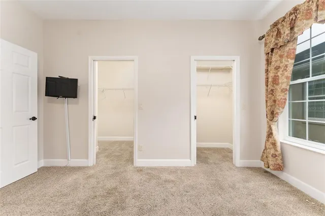 an empty room with windows and closet