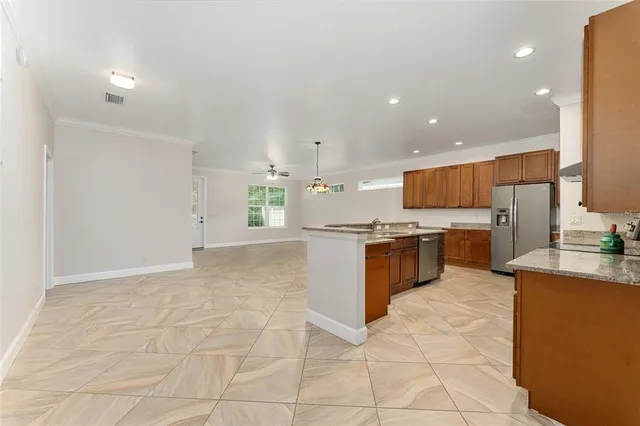 a large kitchen with a large counter top a stove a sink dishwasher and a refrigerator