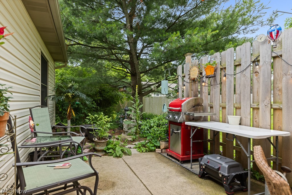 808 Ryan Road, Unit 14 Medina, OH 44256 - Photo 33 of 40 Outdoor patio featuring a concrete surface, privacy fence, and surrounding mature trees