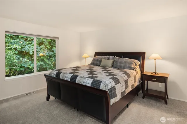 a large bed sitting in a bedroom next to a window