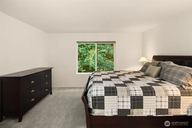 a bedroom with a bed potted plant and a window