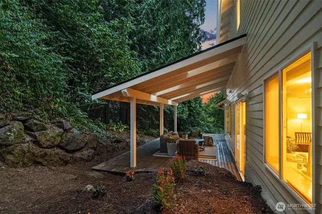 a view of a deck with wooden floor and bench next to a yard