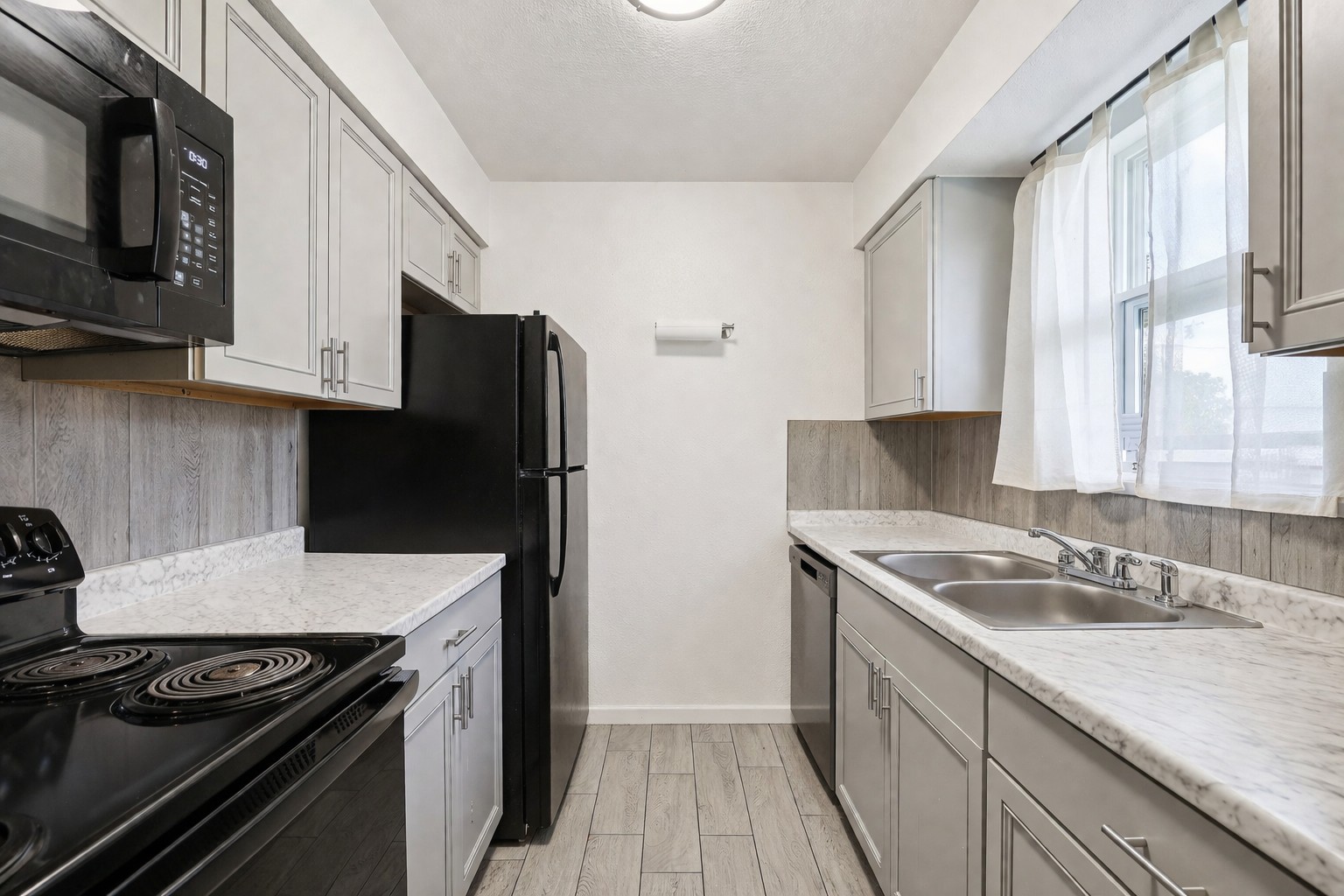 200 Monterrey Street, Unit A & B Elgin, TX 78621 - Photo 14 of 32 Galley kitchen with updated countertops and backsplash. 200 Monterrey, Elgin, TX 78621