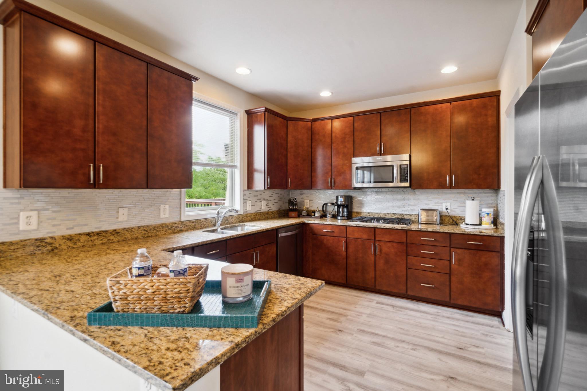 22201 Falling Terrace Ashburn, VA 20148 - Photo 11 of 26 Modern kitchen with rich wood cabinetry.