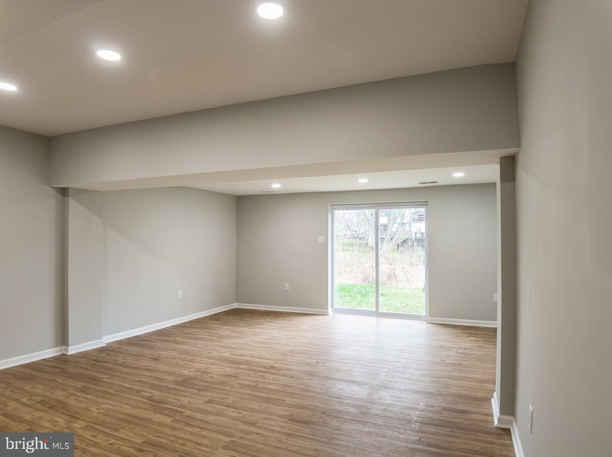 21 Neves Court Baltimore, MD 21234 - Photo 21 of 23 an empty room with wooden floor and windows