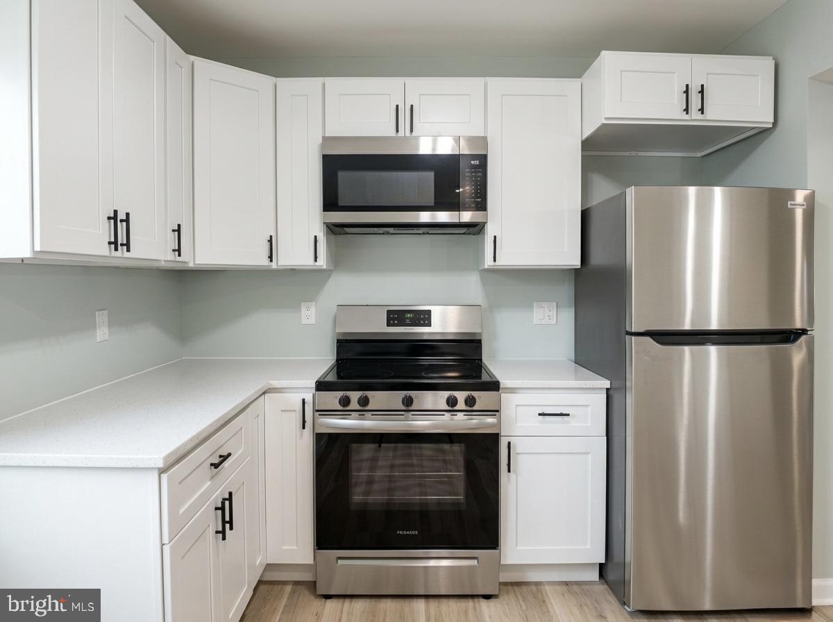 21 Neves Court Baltimore, MD 21234 - Photo 7 of 23 a kitchen with stainless steel appliances a stove a microwave and a refrigerator