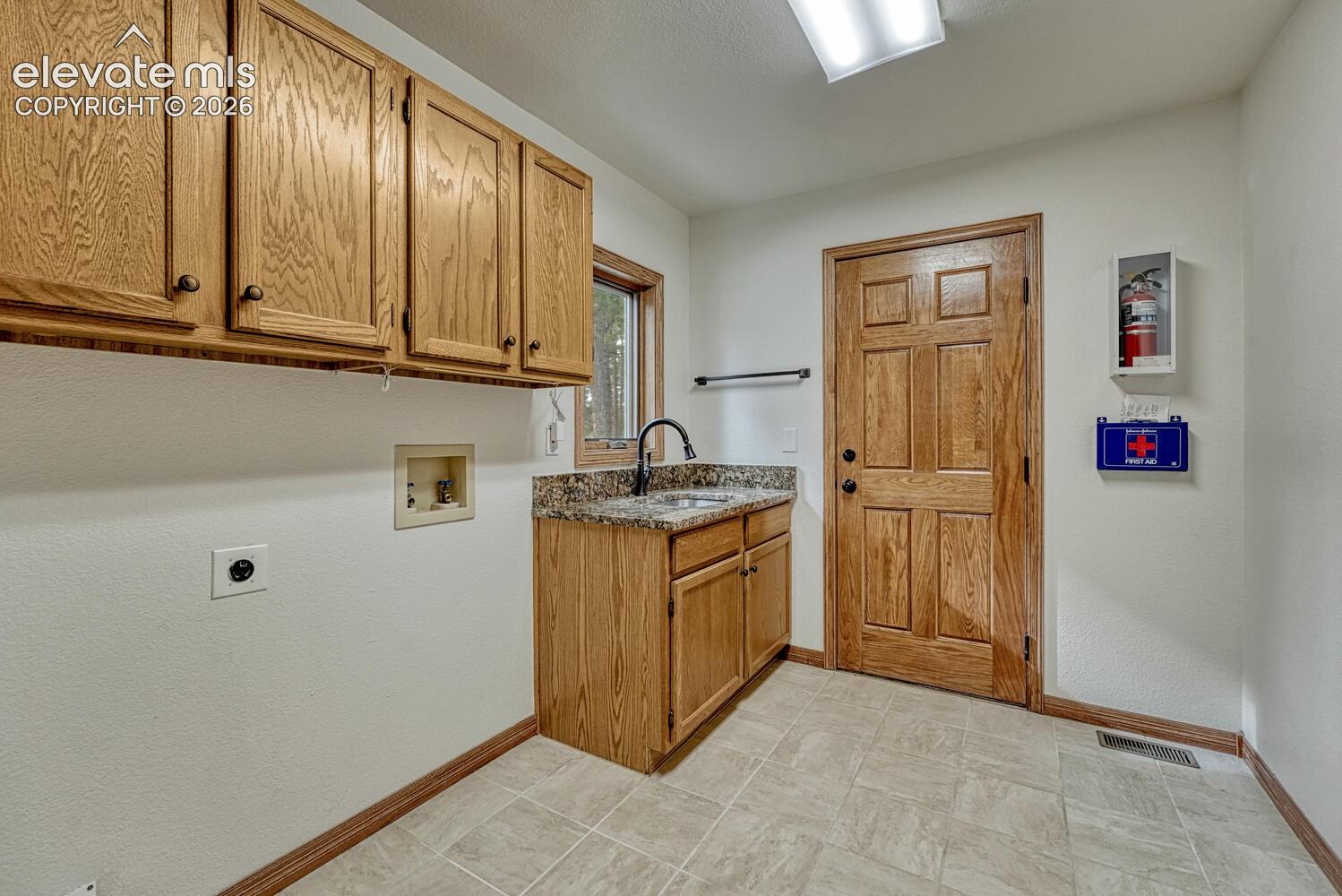 15430 Bar X Road Colorado Springs, CO 80908 - Photo 22 of 50 The Laundry Room features upper cabinetry, a sink, window, and access to an outdoor deck.