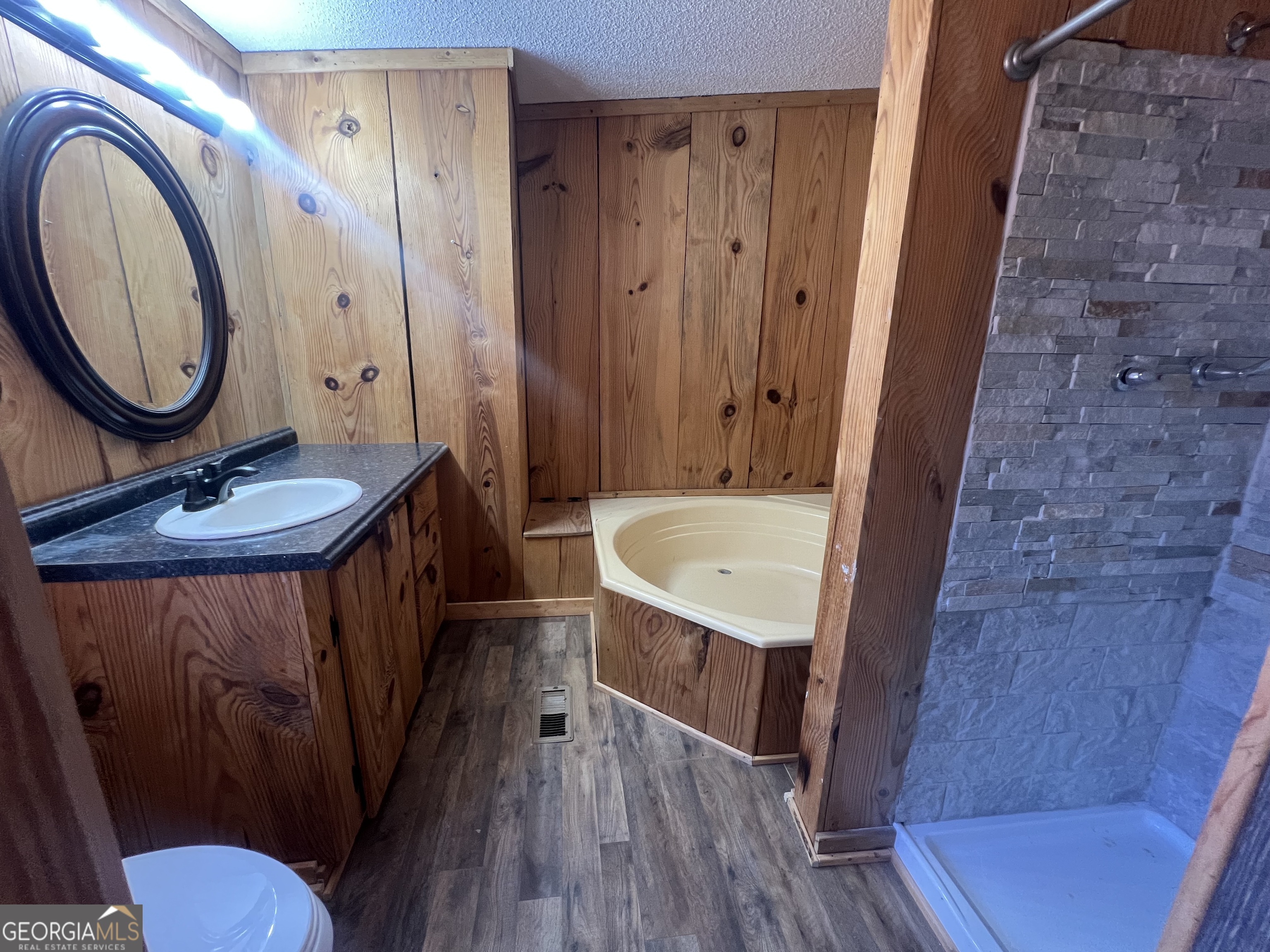 1425 Dowdy Road Roopville, GA 30170 - Photo 18 of 31 a bathroom with a sink a mirror a toilet and a shower