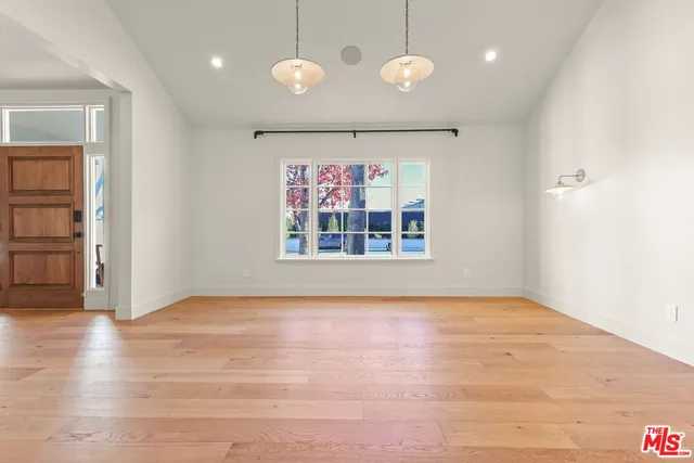 a large kitchen with stainless steel appliances kitchen island granite countertop a large stove a sink dishwasher and white cabinets with wooden floor