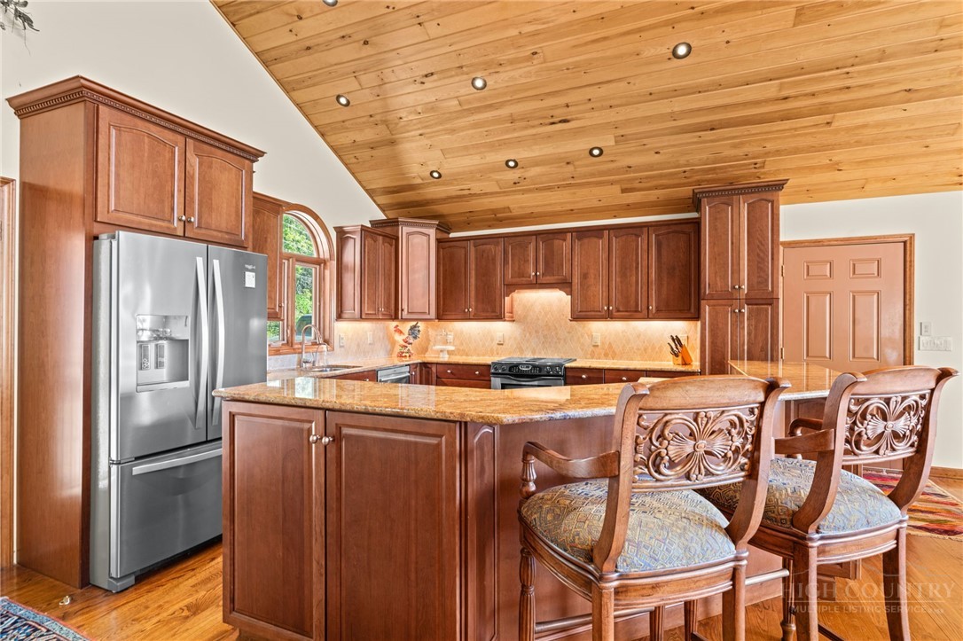 331 Alpine Road Blowing Rock, NC 28605 - Photo 18 of 50 a kitchen with stainless steel appliances granite countertop a stove and a refrigerator