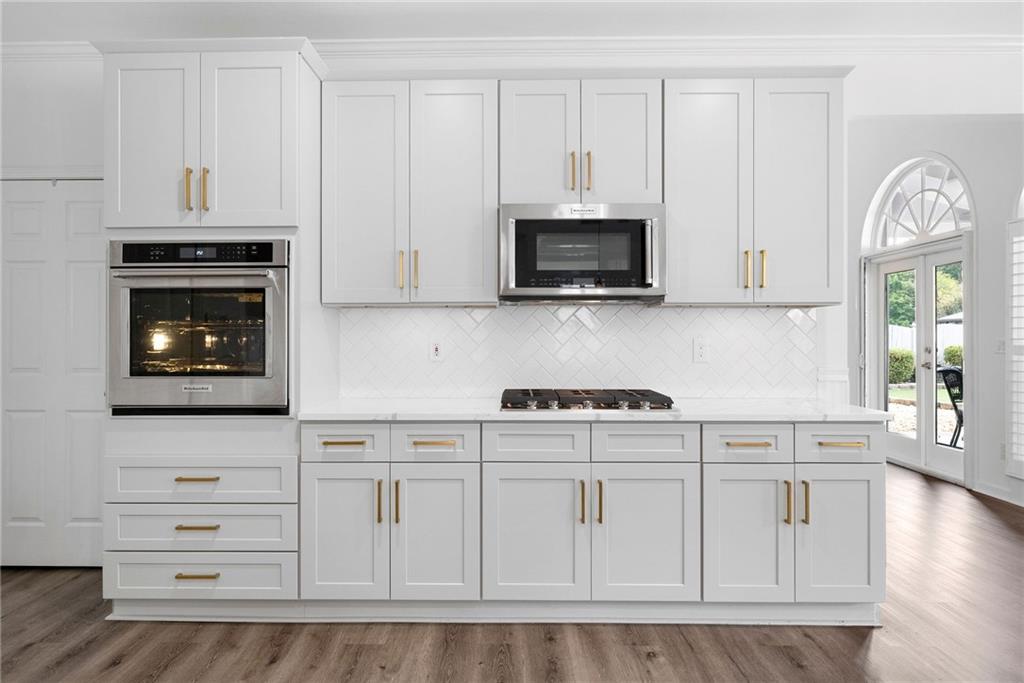 820 Nob Ridge Drive Southwest Marietta, GA 30064 - Photo 14 of 45 a kitchen with white cabinets stainless steel appliances and wooden floor