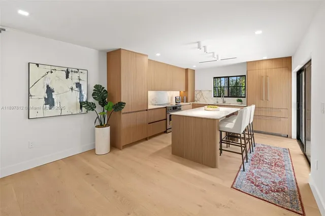 a room with stainless steel appliances kitchen island granite countertop furniture and a potted plant