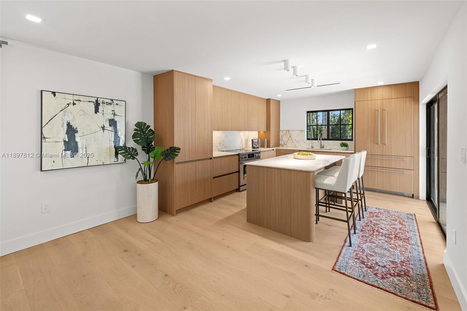 8858 Garland Avenue Surfside, FL 33154 - Photo 11 of 37 a room with stainless steel appliances kitchen island granite countertop furniture and a potted plant