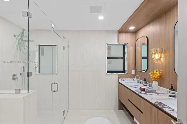a bathroom with a double vanity sink mirror and shower