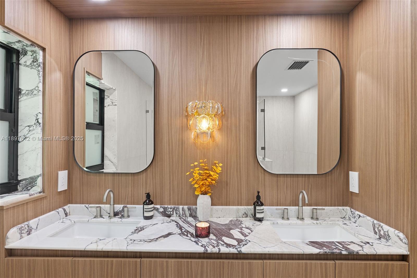 8858 Garland Avenue Surfside, FL 33154 - Photo 18 of 37 a bathroom with a granite countertop double vanity sinks and a mirror