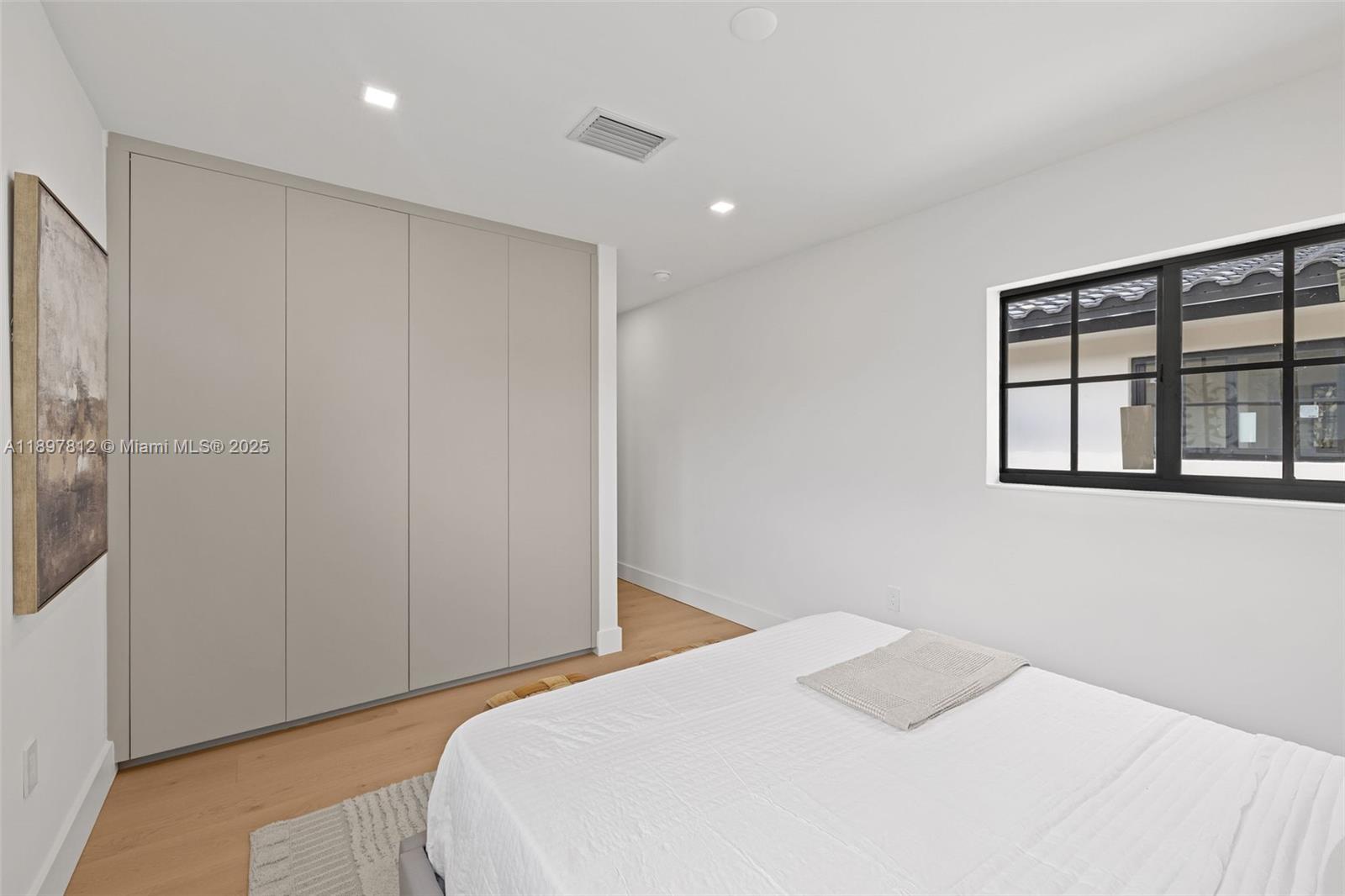 8858 Garland Avenue Surfside, FL 33154 - Photo 21 of 37 a bedroom with a bed and a window