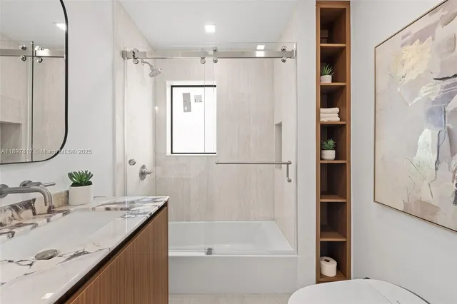 a bathroom with a granite countertop sink toilet and shower