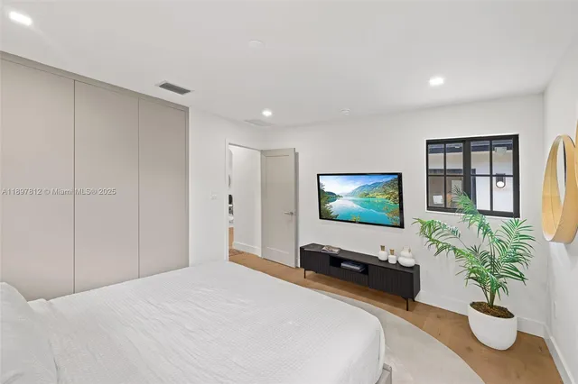 a bedroom with a bed and a flat screen tv
