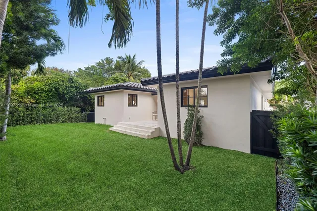 a backyard of a house with plants and tree