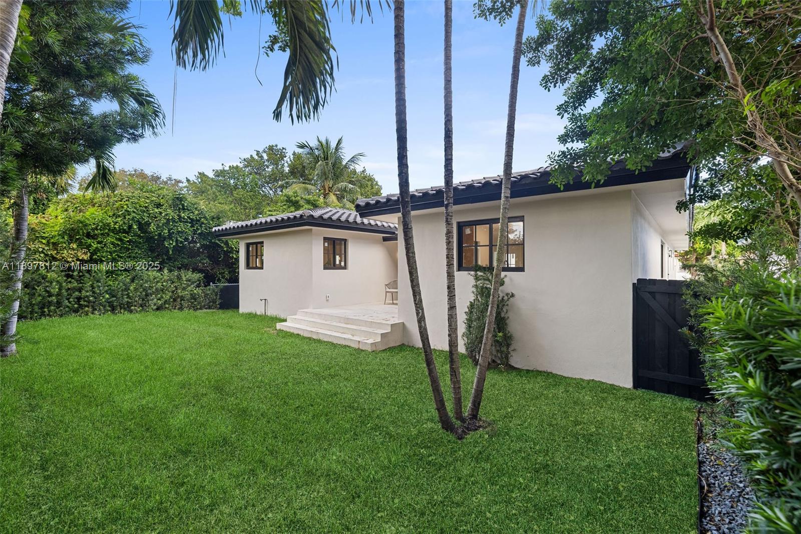 8858 Garland Avenue Surfside, FL 33154 - Photo 31 of 37 a backyard of a house with plants and tree