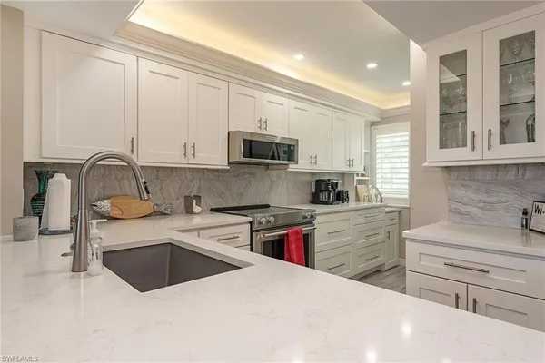 a kitchen with granite countertop a sink stainless steel appliances and cabinets