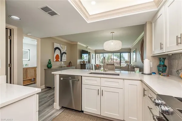 a kitchen with white cabinets and sink