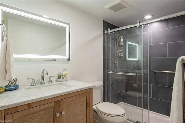 a bathroom with a sink a toilet and shower