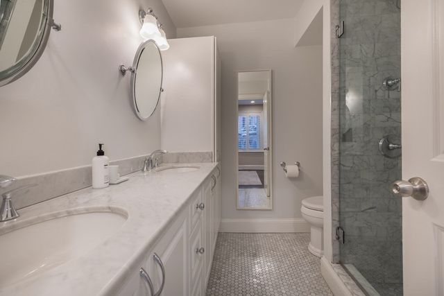 a spacious bathroom with a granite countertop sink a toilet and a shower