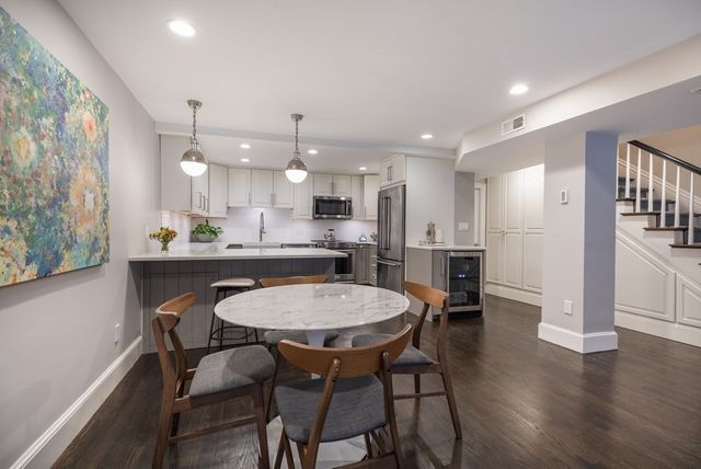 a kitchen with a dining table chairs refrigerator and cabinets