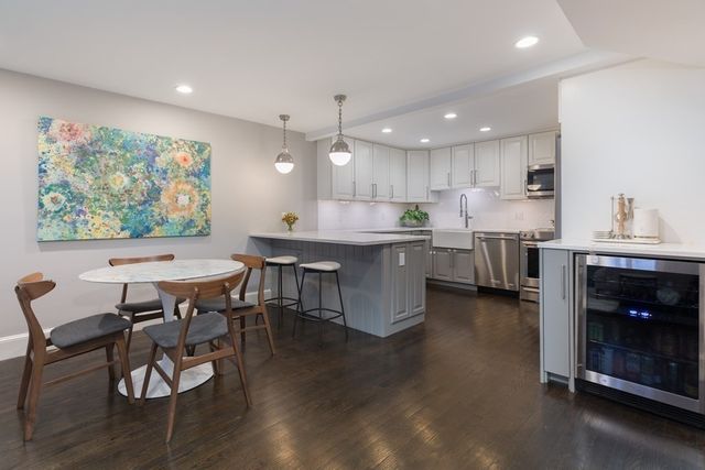 a open kitchen with stainless steel appliances granite countertop a table chairs and a sink