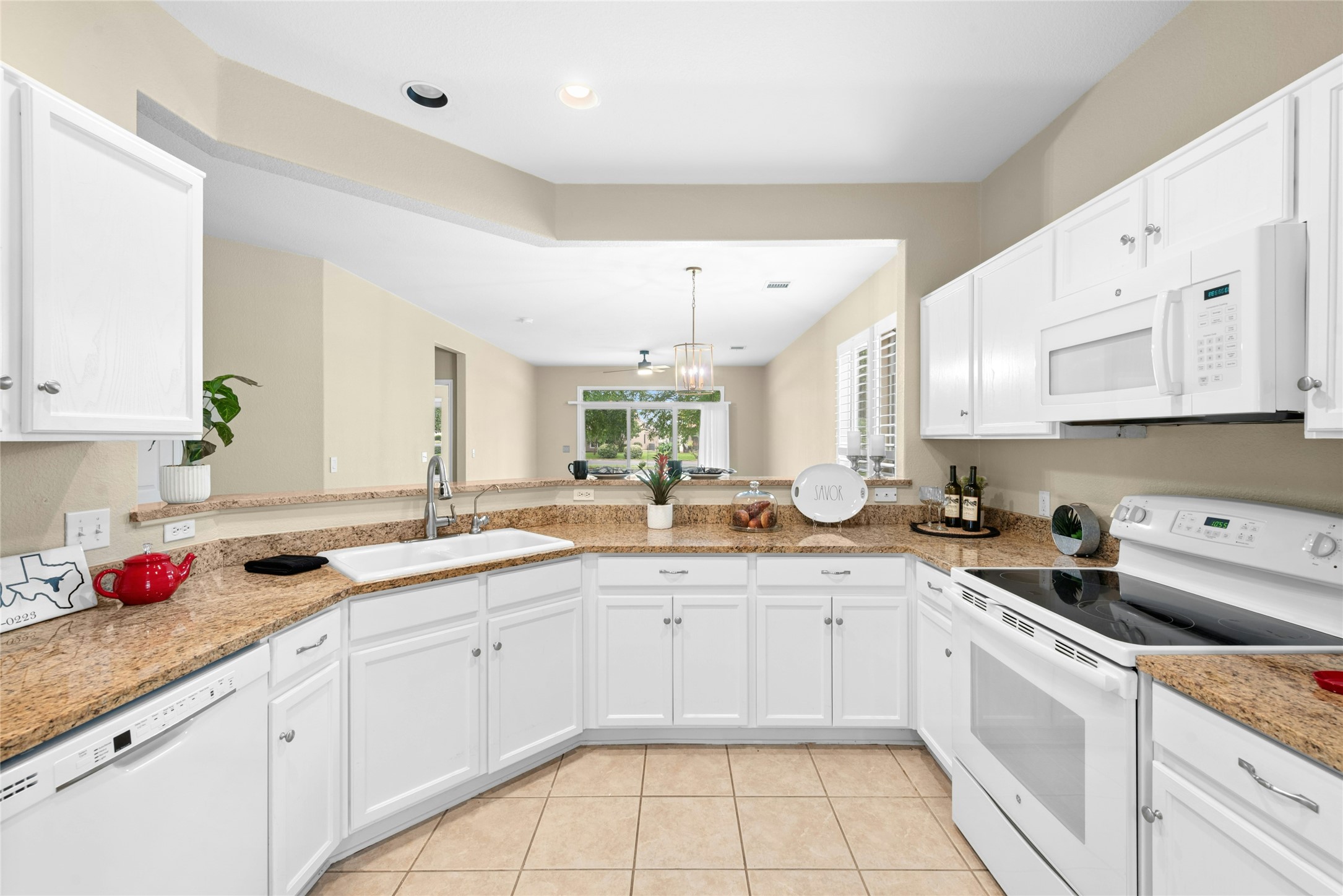 111 Hampton Circle Georgetown, TX 78633 - Photo 11 of 34 a kitchen with granite countertop a sink white cabinets and white appliances