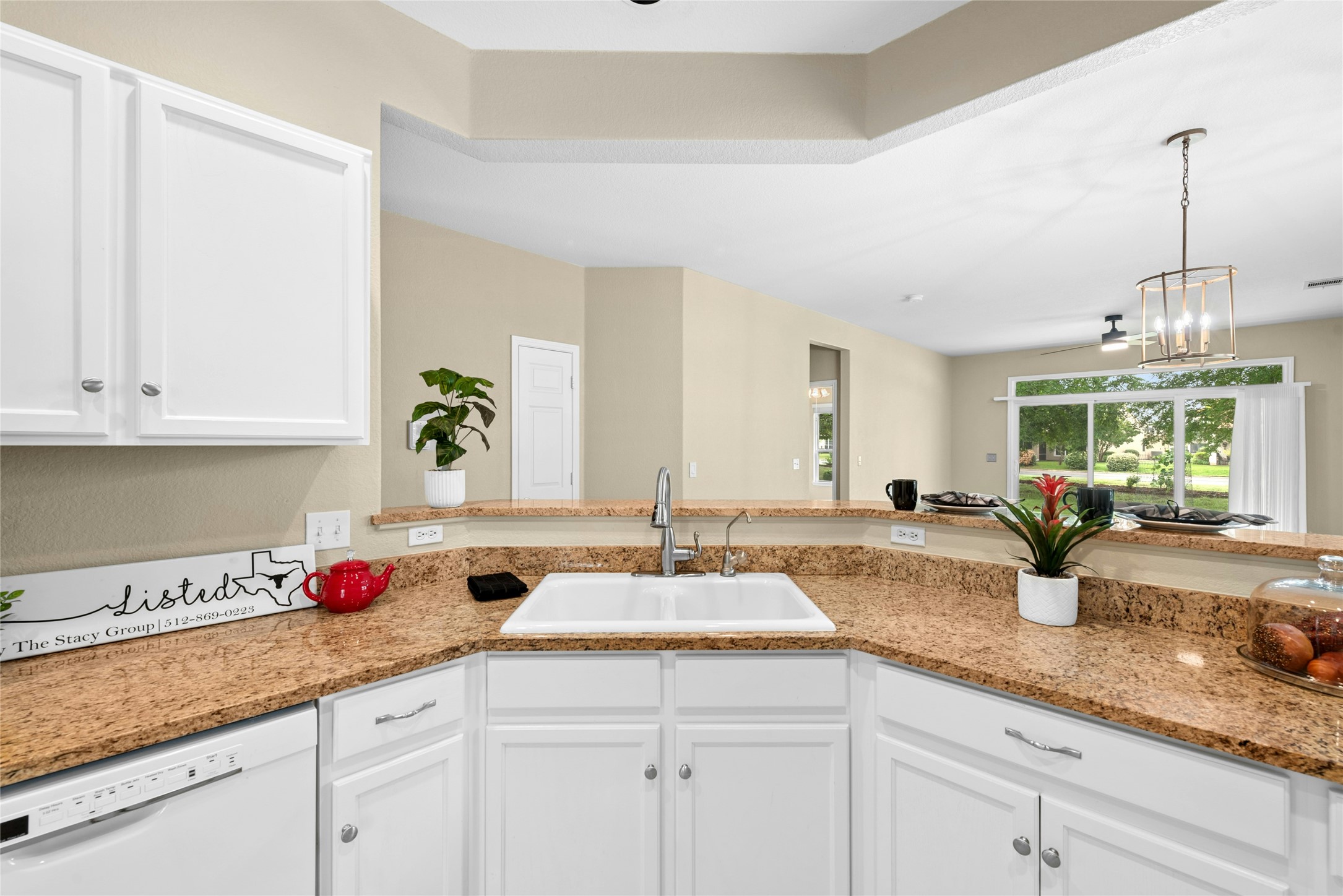 111 Hampton Circle Georgetown, TX 78633 - Photo 12 of 34 a kitchen with granite countertop a sink white cabinets and a wooden floor