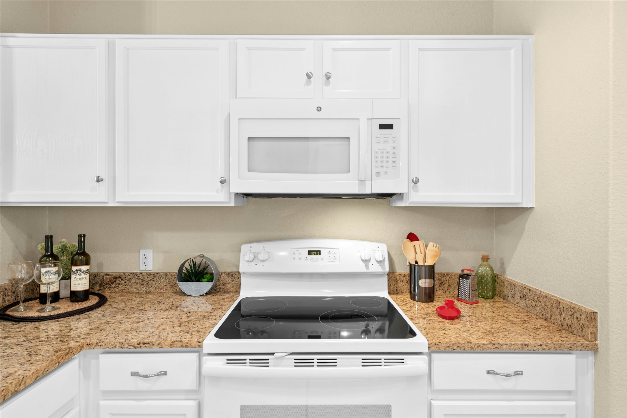 111 Hampton Circle Georgetown, TX 78633 - Photo 14 of 34 a kitchen with white cabinets and a stove with wooden floor