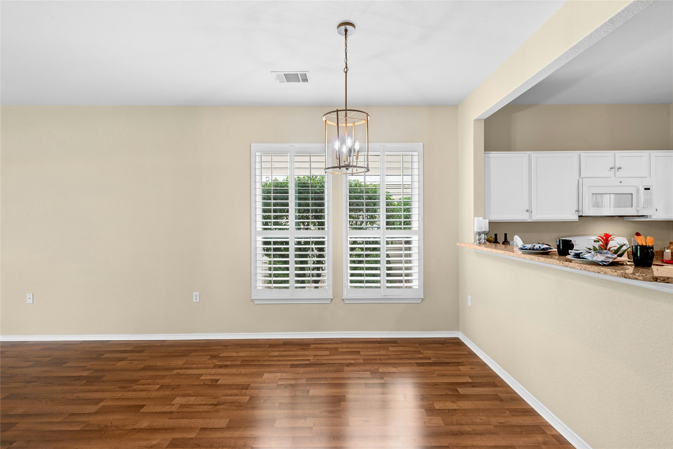 111 Hampton Circle Georgetown, TX 78633 - Photo 10 of 34 a view of a kitchen with a sink dishwasher and microwave with wooden floor