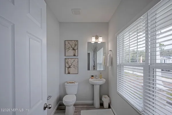 a dining room with furniture potted plants and wooden floor