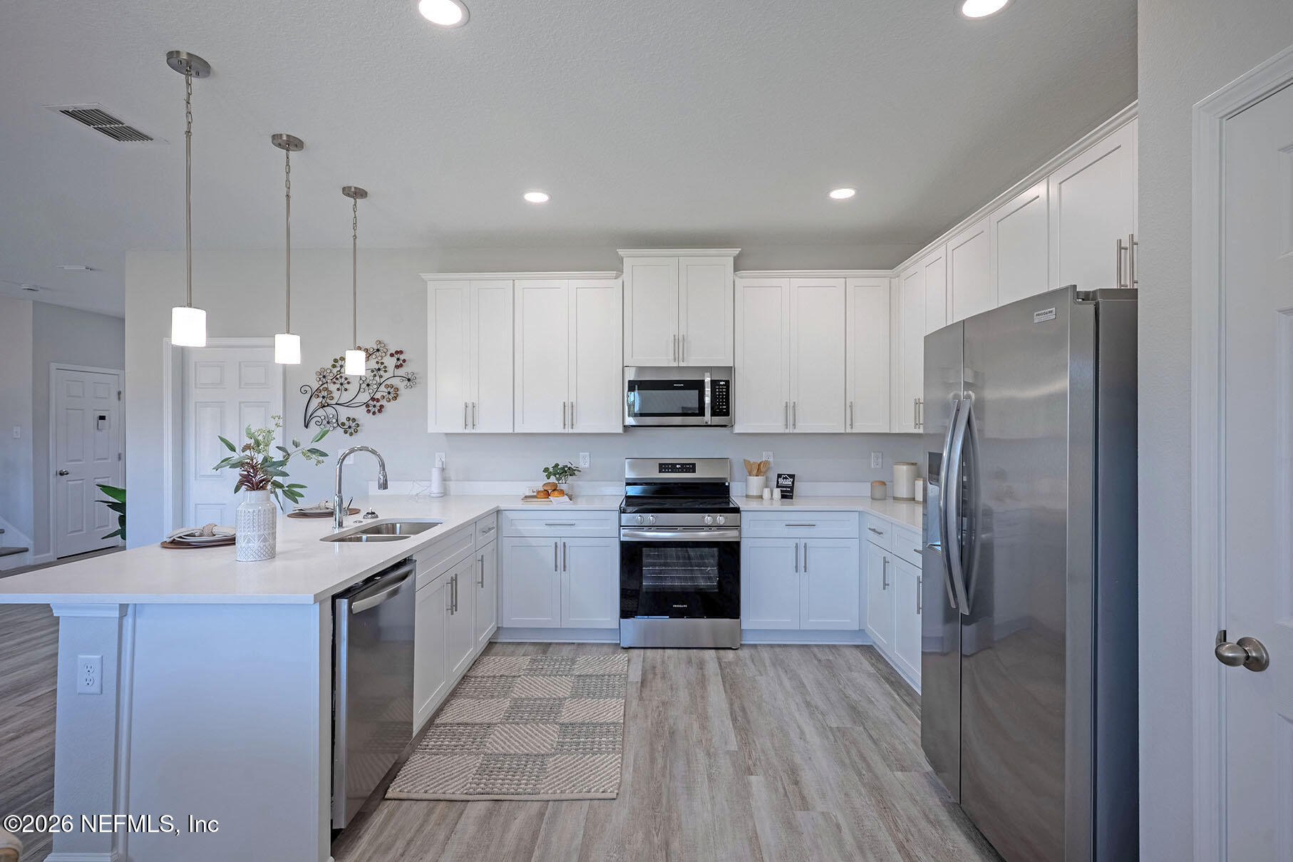 1223 Jewelstone Lane Jacksonville, FL 32221 - Photo 29 of 46 a kitchen with kitchen island white cabinets stainless steel appliances and a center island