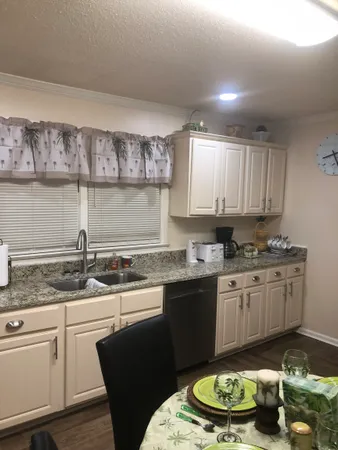 a kitchen with granite countertop a stove a sink and a microwave