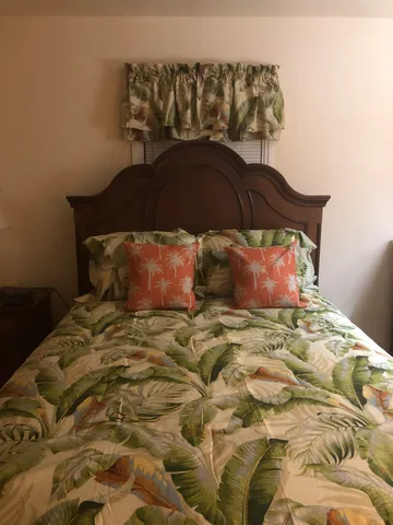 a bedroom with a bed and a painting on the wall