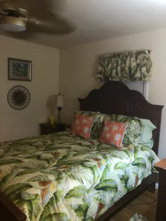 a bedroom with a bed and a lamp on dresser
