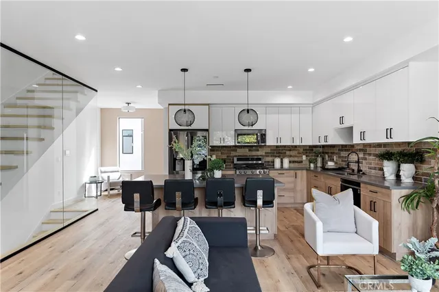 a living room with lots of furniture and kitchen view