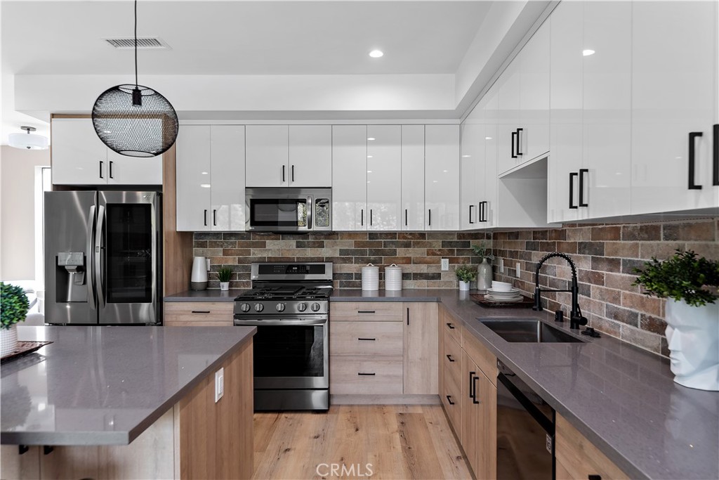 11857 West Flower Ln Valley Village Valley Village, CA 91607 - Photo 11 of 54 a kitchen with stainless steel appliances a sink a stove a microwave a center island and cabinets
