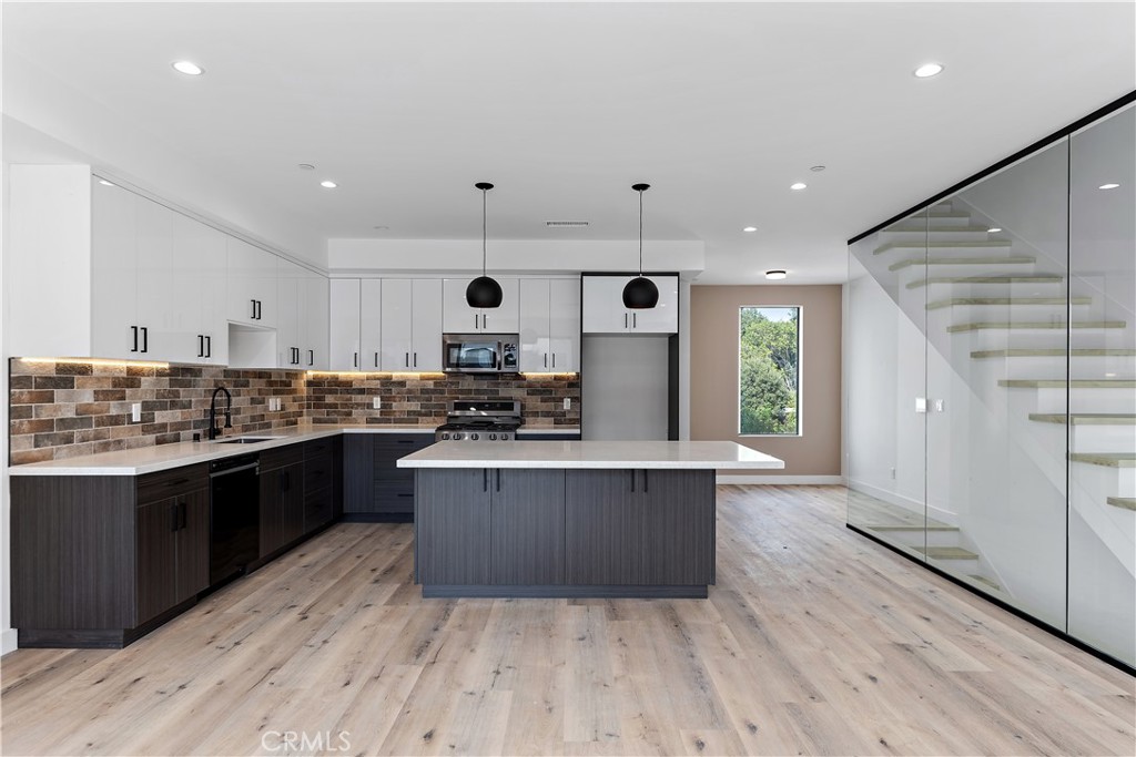 11857 West Flower Ln Valley Village Valley Village, CA 91607 - Photo 36 of 54 a large kitchen with stainless steel appliances kitchen island granite countertop a stove and a wooden floors