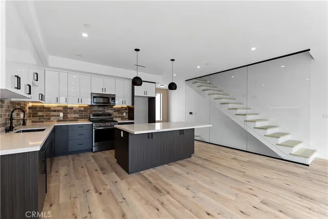 a kitchen with a stove a counter space and wooden floor