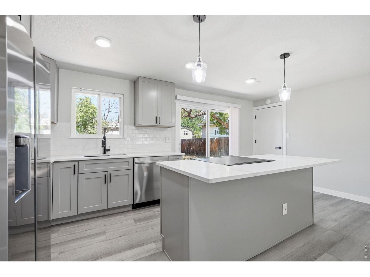 1035 6th Street Berthoud, CO 80513 - Photo 10 of 37 a kitchen with kitchen island granite countertop a sink stainless steel appliances and cabinets